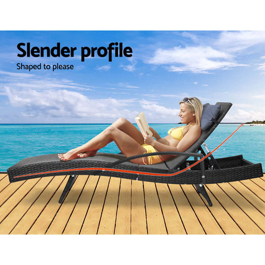 A woman relaxing on a Gardeon sun lounge by the beach, enjoying reading in a comfortable adjustable position.