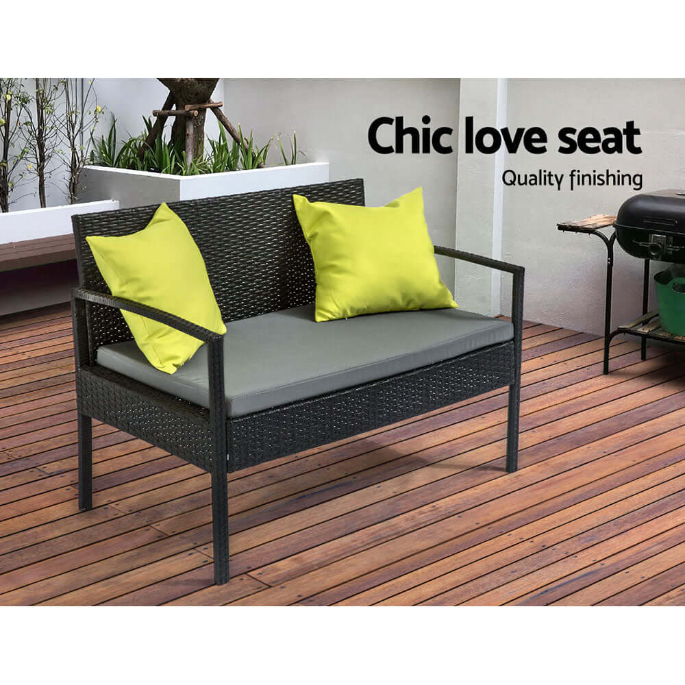 Chic outdoor love seat with quality finishing, gray cushion and vibrant yellow pillows on a wooden deck.