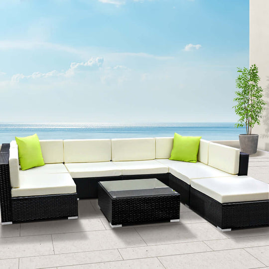 Gardeon 8-Piece Outdoor Sofa Set with green cushions and glass-top table against ocean view, perfect for affordable luxury.