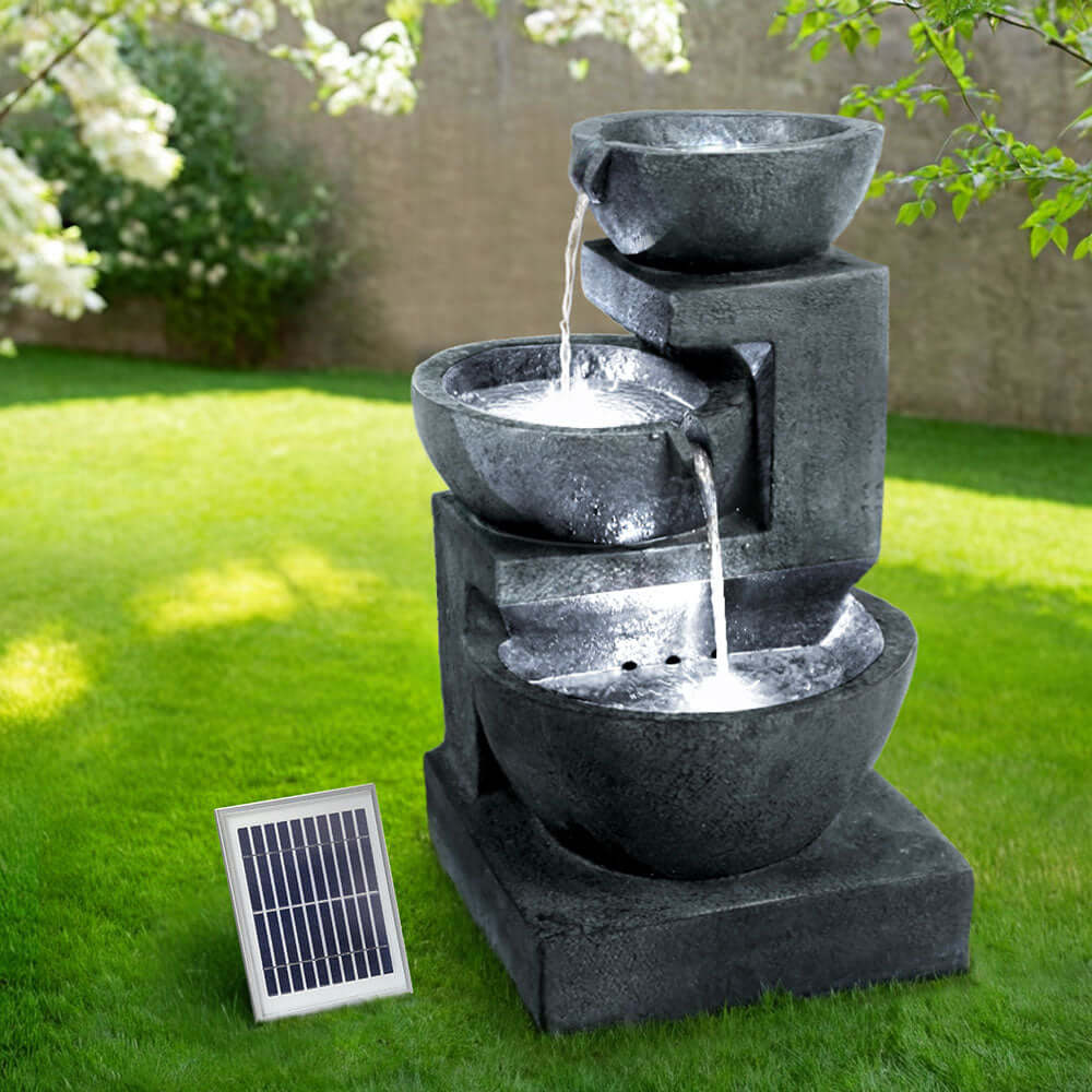 Gardeon Solar Water Feature: 3-Tier Cascading Fountain with LED lights in a garden, showcasing affordable luxury for outdoor decor.