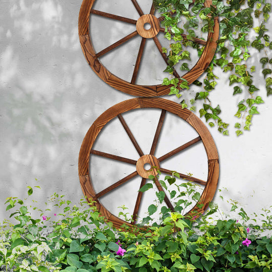 Gardeon wooden wagon wheels hanging on a wall with greenery and flowers, perfect for affordable DIY garden decor.