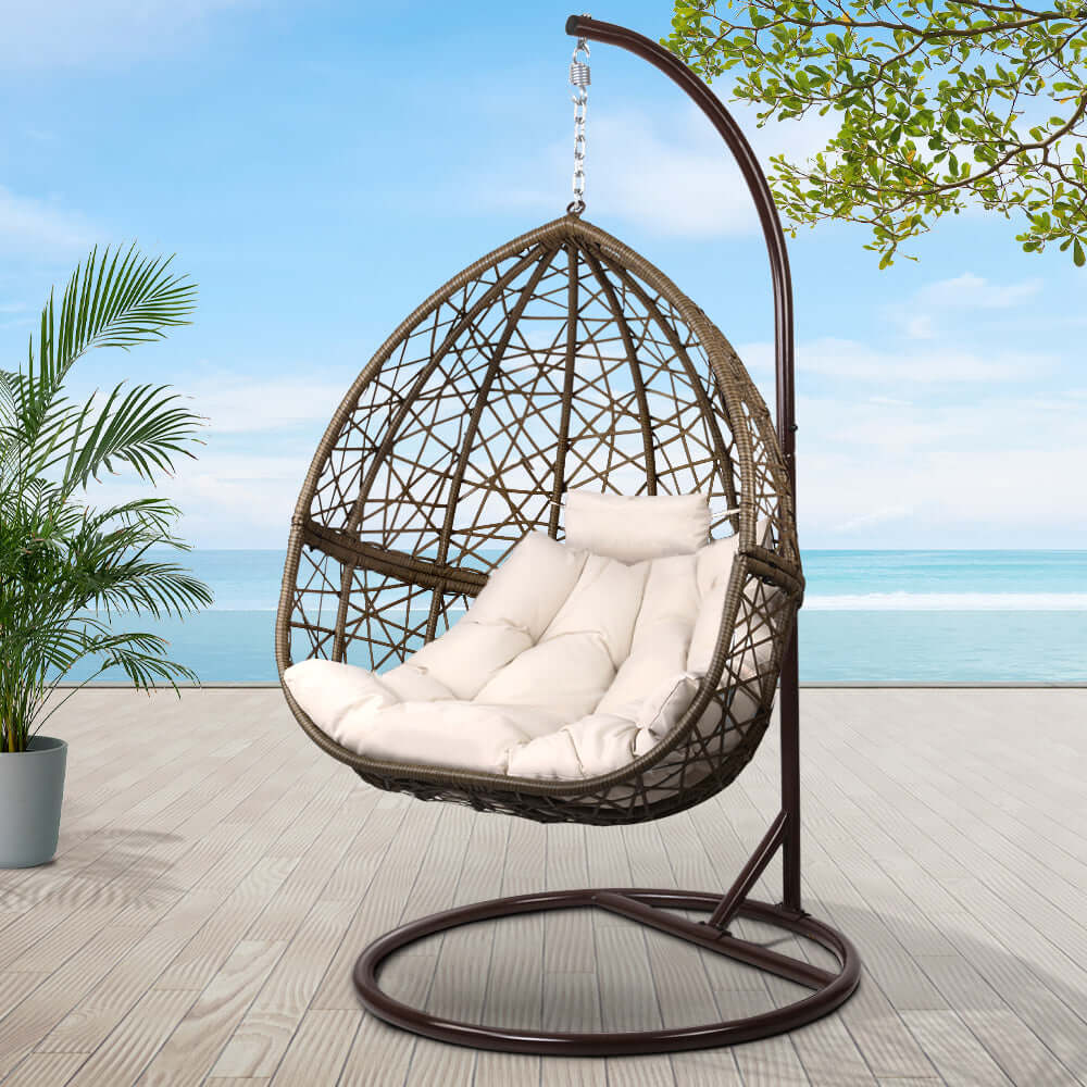 Gardeon outdoor egg swing chair in brown wicker with soft cushion, perfect for affordable luxury and relaxation in any outdoor space.