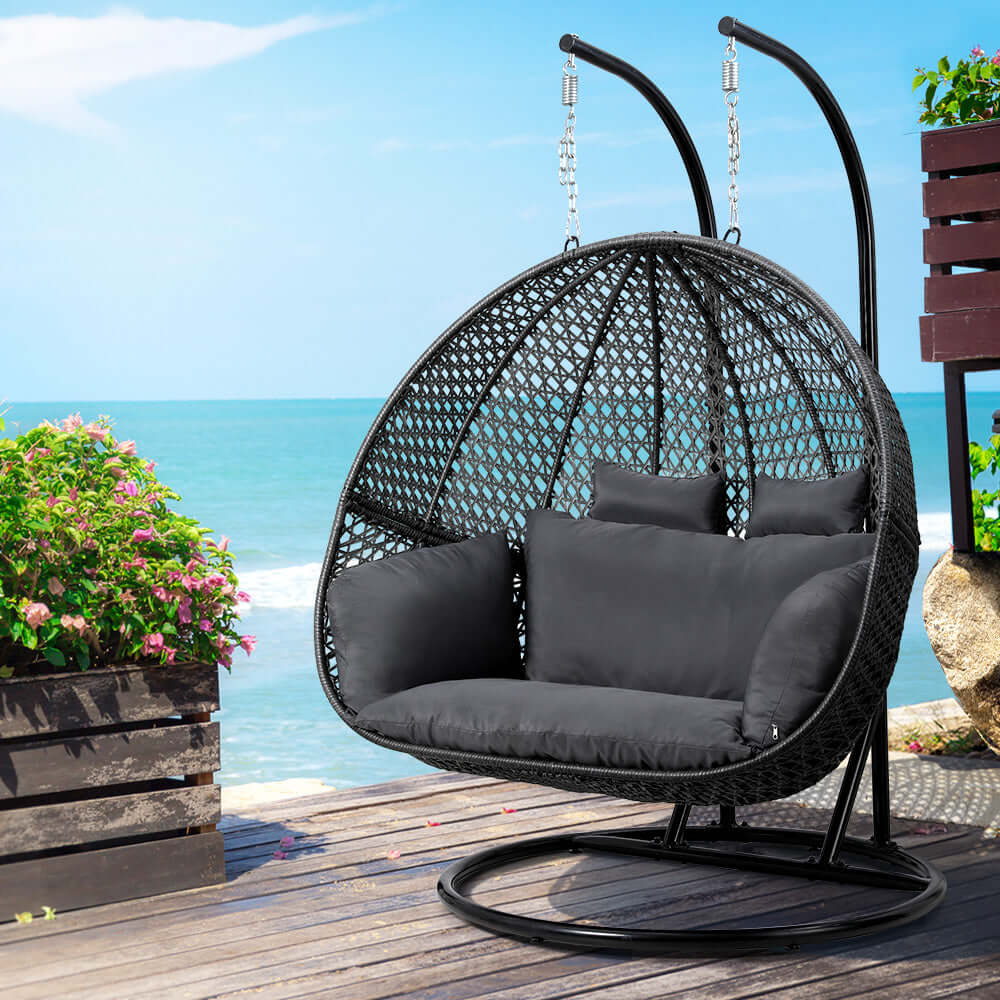 Gardeon grey egg swing chair with cushions, ideal for outdoor relaxation by the beach or poolside.