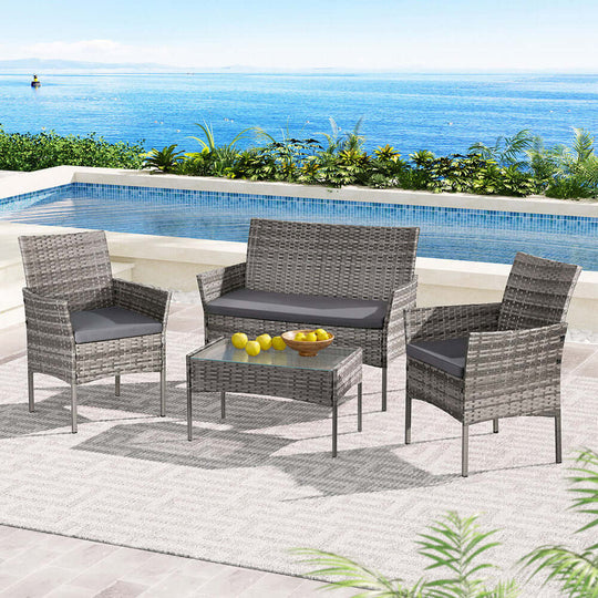 Gardeon 4 seater grey wicker outdoor sofa set by the pool, featuring stylish chairs and a glass-top table.