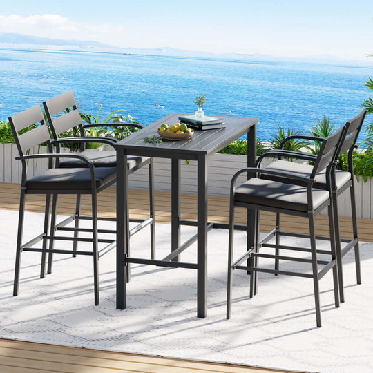 Gardeon 5-piece outdoor bar set with aluminum frame and cushioned stools, perfect for a patio dining area by the sea.