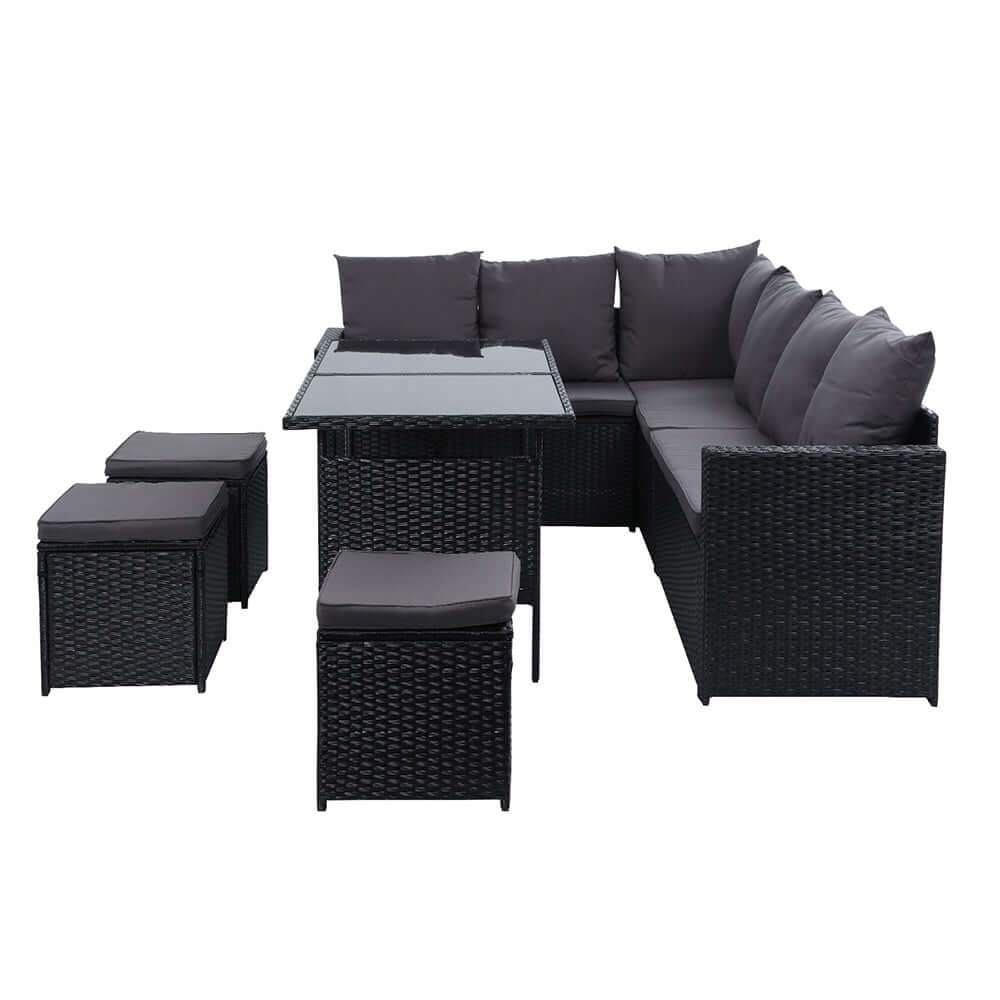 Gardeon 9-seater outdoor wicker sofa dining set in black, featuring cushions and a glass-top table.