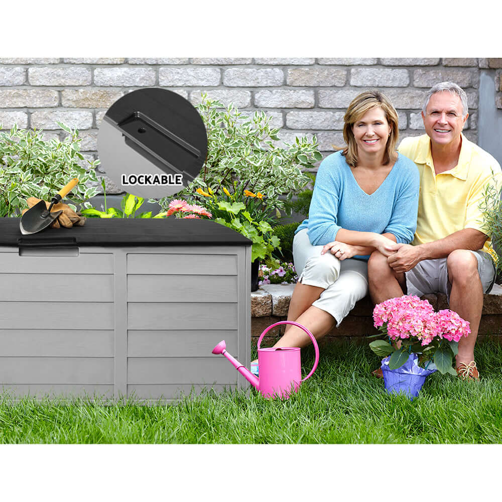 Couple enjoying their garden beside a 290L lockable Gardeon outdoor storage box, showcasing affordable and quality outdoor organization.