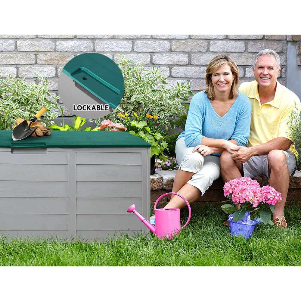 Couple sitting by Gardeon 290L Lockable Outdoor Storage Box, showcasing practical garden organization.