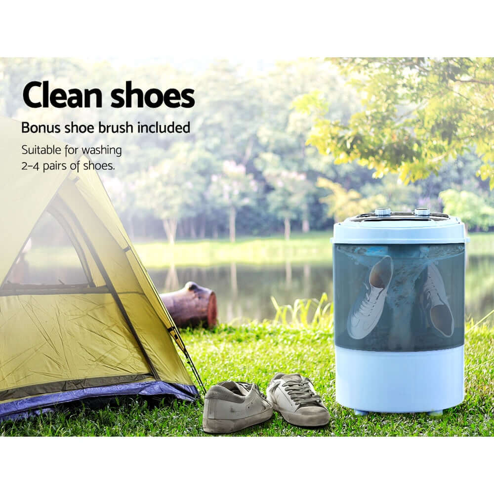 Devanti Portable Washing Machine cleaning shoes at a camping site near a tent and lake, suitable for washing 2-4 pairs of shoes.