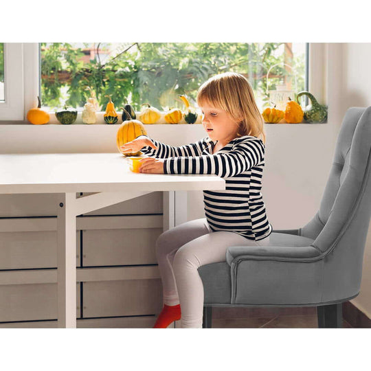 Child sitting on Artiss Dining Chair in grey upholstered velvet, surrounded by autumn decor, emphasizing French Provincial style.