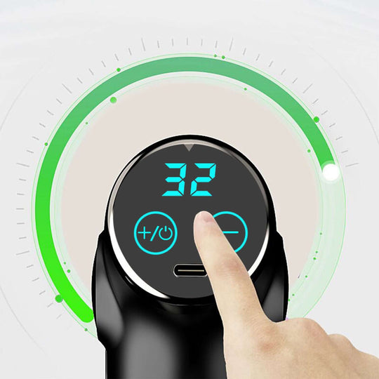 Close-up of FitSmart LCD display showing level 32 on a mini vibration therapy massage device with user adjusting settings.