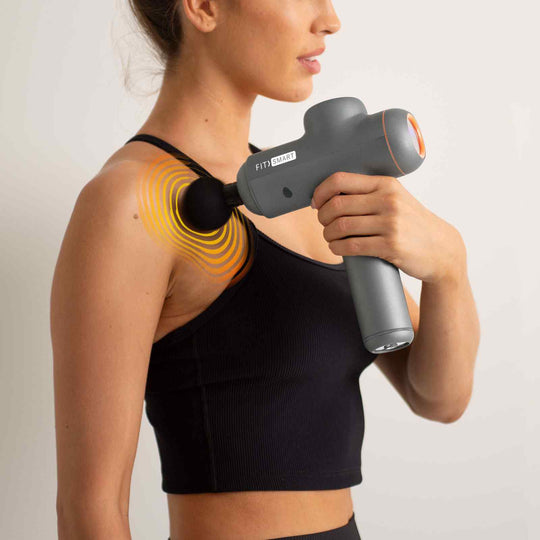 Woman using the FitSmart Power-X Massage Gun on her shoulder, showcasing affordable vibration therapy for muscle relief and recovery.