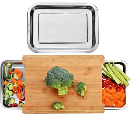 Affordable bamboo chopping board with 2 stainless steel trays holding fresh vegetables for efficient meal prep.