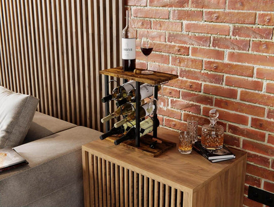 Stylish wooden and metal wine rack holding 6 bottles and a glass on a modern countertop next to a cozy sofa.