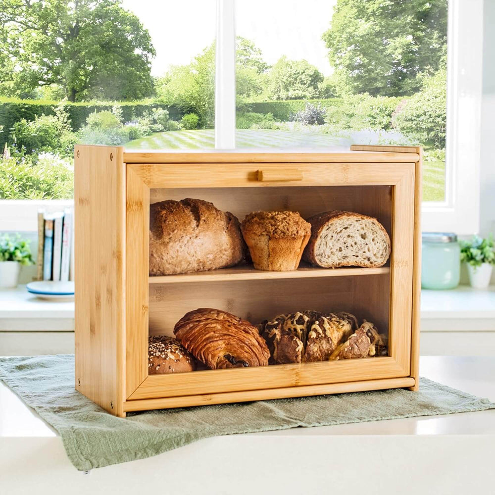 Double layer bamboo bread box with transparent window, showcasing various breads and rolls on kitchen counter.