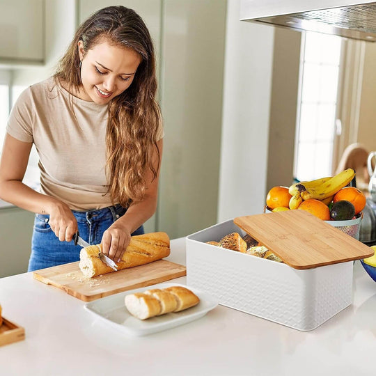 Woman slicing bread on chopping board near stylish bread bin with bamboo lid, showcasing DIY kitchen organization.