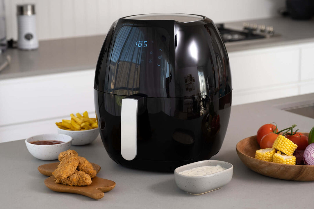 8L digital air fryer on kitchen counter with fried chicken, fries, and fresh vegetables, showcasing non-stick feature and 8 cooking programs.