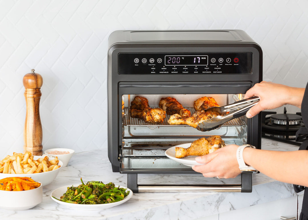 23L Digital Air Fryer Convection Oven with rotisserie chicken and side dishes, showcasing affordable quality kitchen appliance for family meals.