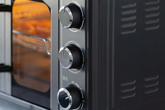 Close-up of 30L air fryer convection oven control knobs for precise cooking and temperature settings.