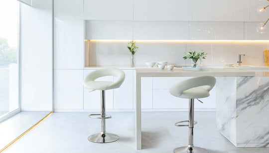 Stylish white leather barstools with adjustable height in modern kitchen setting, enhancing affordable luxe decor.