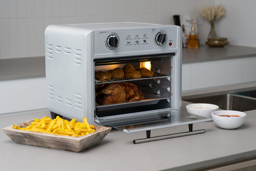 23L silver air fryer oven cooking chicken and fries in a modern kitchen with affordable and quality value furniture.