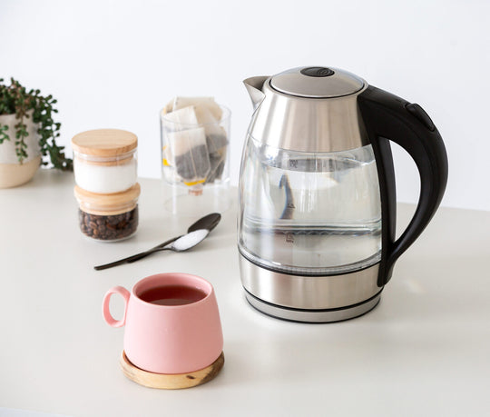 1.7 Litre Glass Kettle with 360° Rotational Base on kitchen counter with a pink cup and tea accessories.