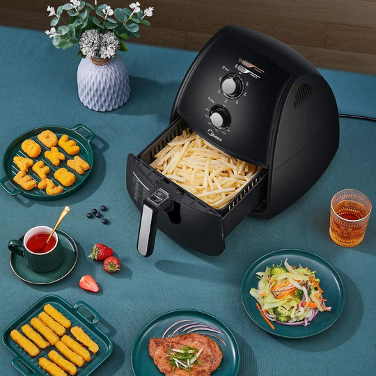 Midea 4L 1500W multi-functional air fryer with fries on a table with various foods and drinks, showcasing quality and affordable value furniture.