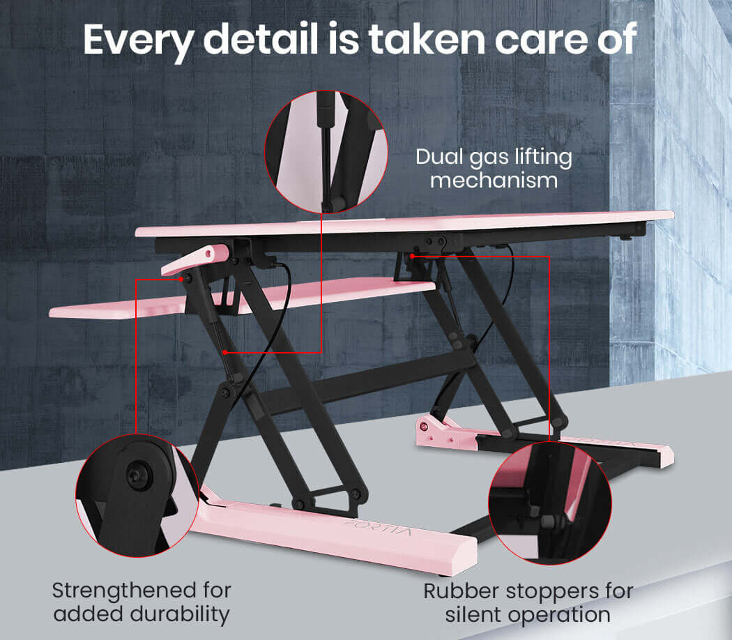 Fortia Desk Riser details showcasing dual gas lifting, rubber stoppers, and durability features in pink.