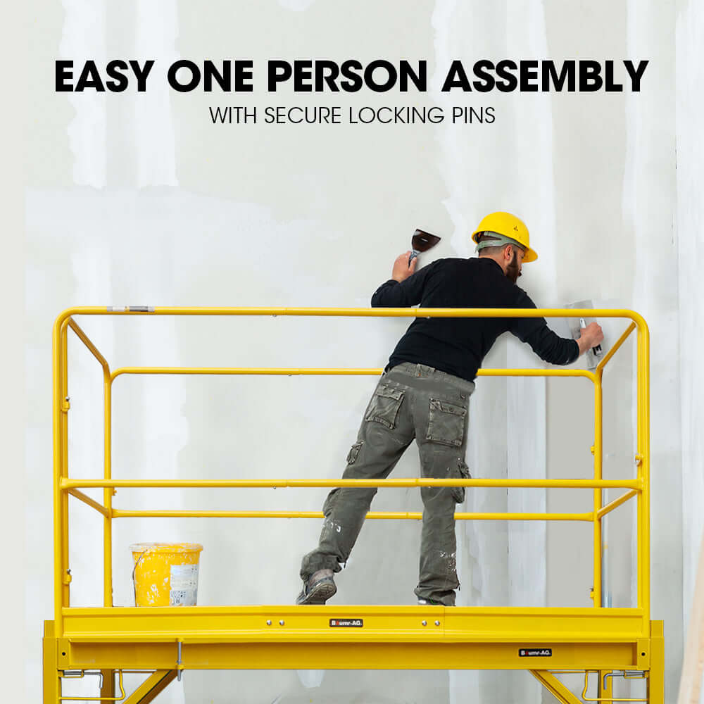 Worker assembling Baumr-AG mobile scaffold with secure locking pins for safety and stability.