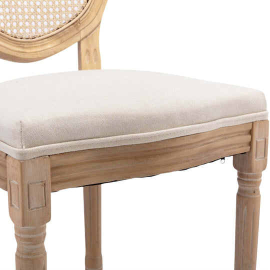 Beige upholstered seat of a vintage French dining chair with solid wood legs, showcasing quality craftsmanship and elegance.