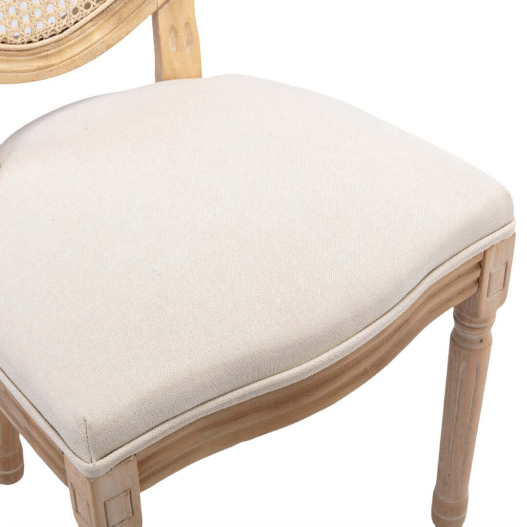 Beige upholstered seat of vintage French dining chair with intricately carved wooden frame. Affordable luxury for your dining space.