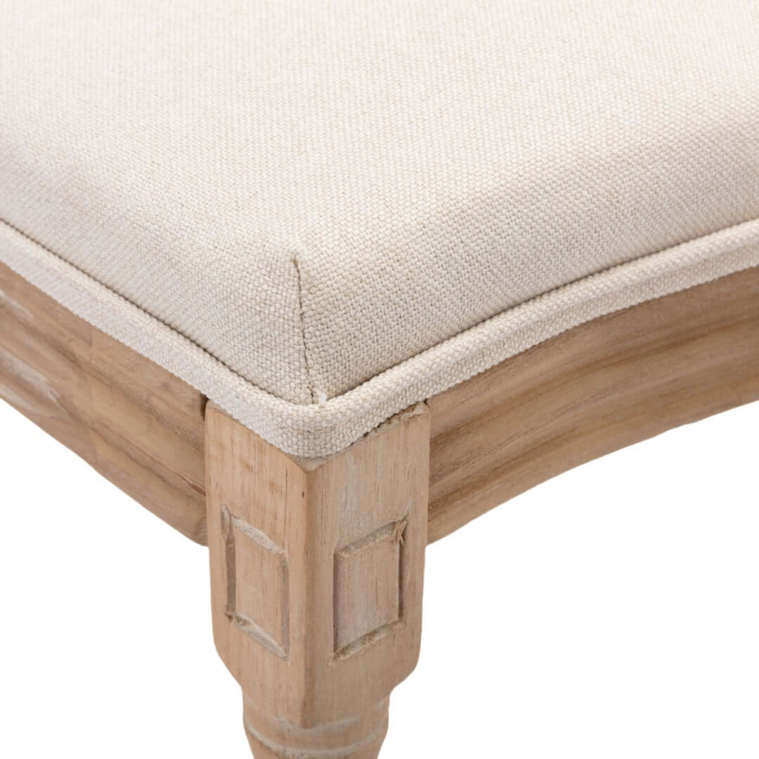 Close-up of beige upholstered seat cushion with solid wood frame detailing, showcasing quality craftsmanship and luxurious design.