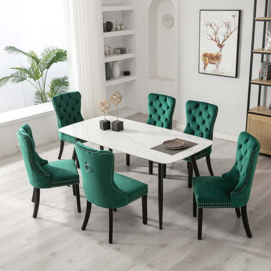 Modern green velvet dining chairs with tufted backs around a white marble table in a stylish setting.