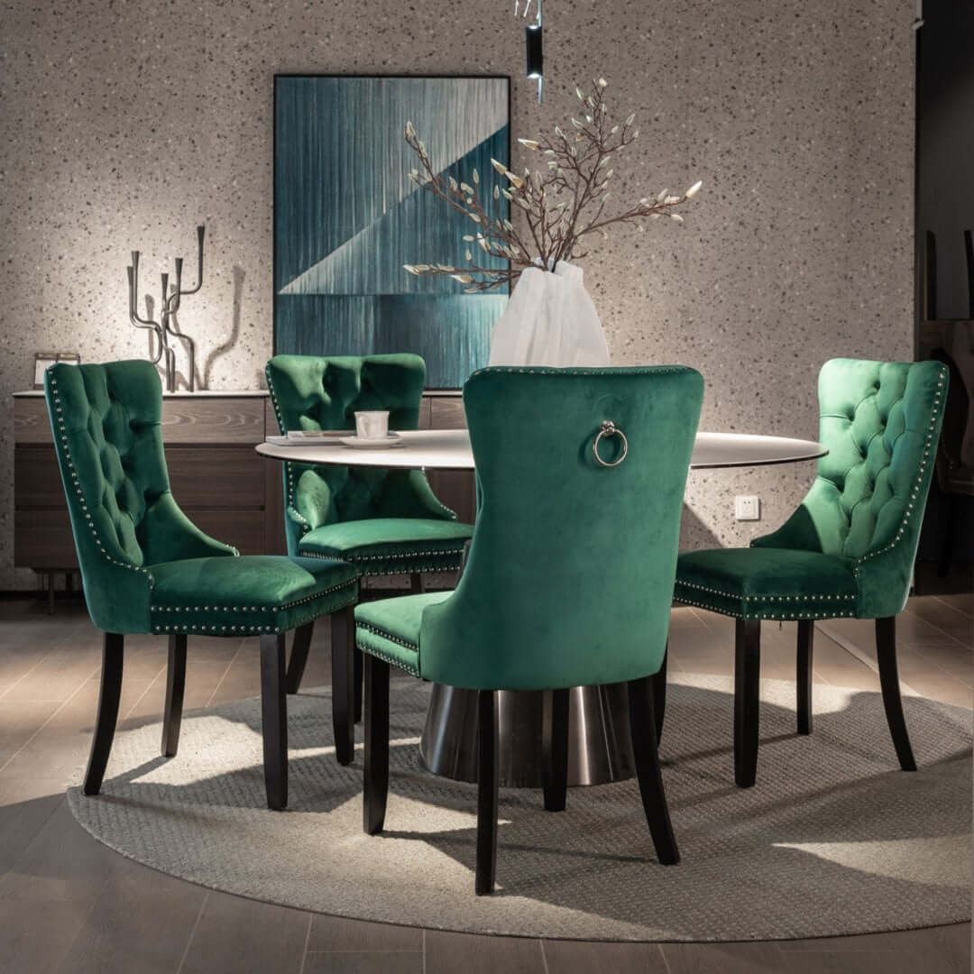 Elegant green velvet dining chairs with high backs and tufted design around a modern circular dining table.