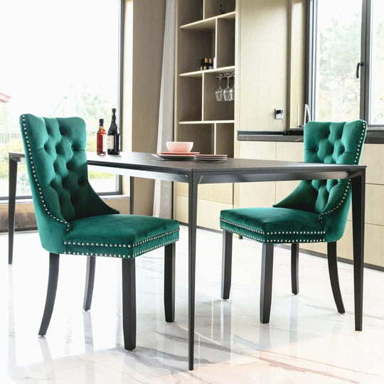 Stylish green velvet dining chairs with tufted backs and studs, paired with a modern table in a contemporary dining setting.