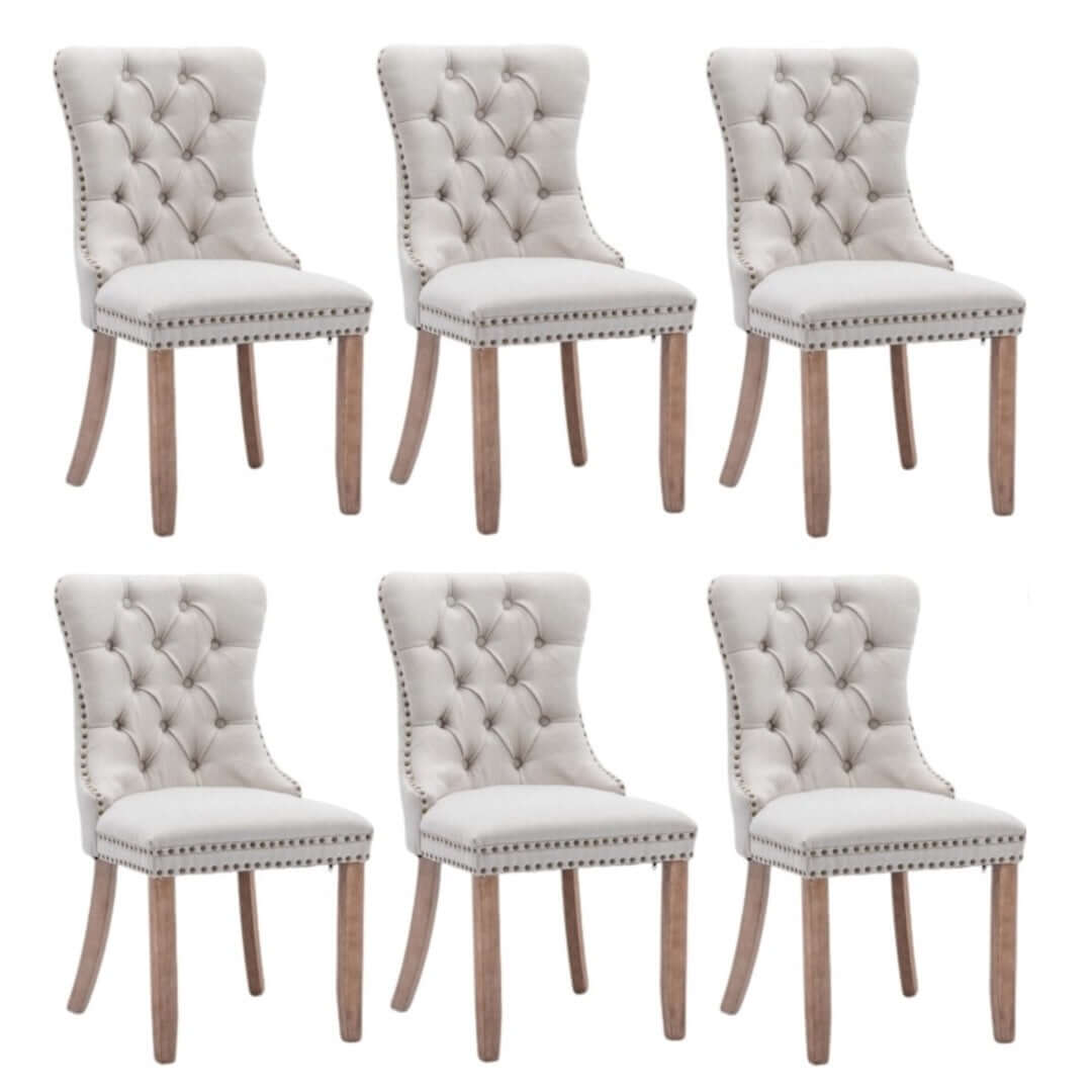 Set of 6 elegant button-tufted upholstered dining side chairs in beige with stud trim and wooden legs.