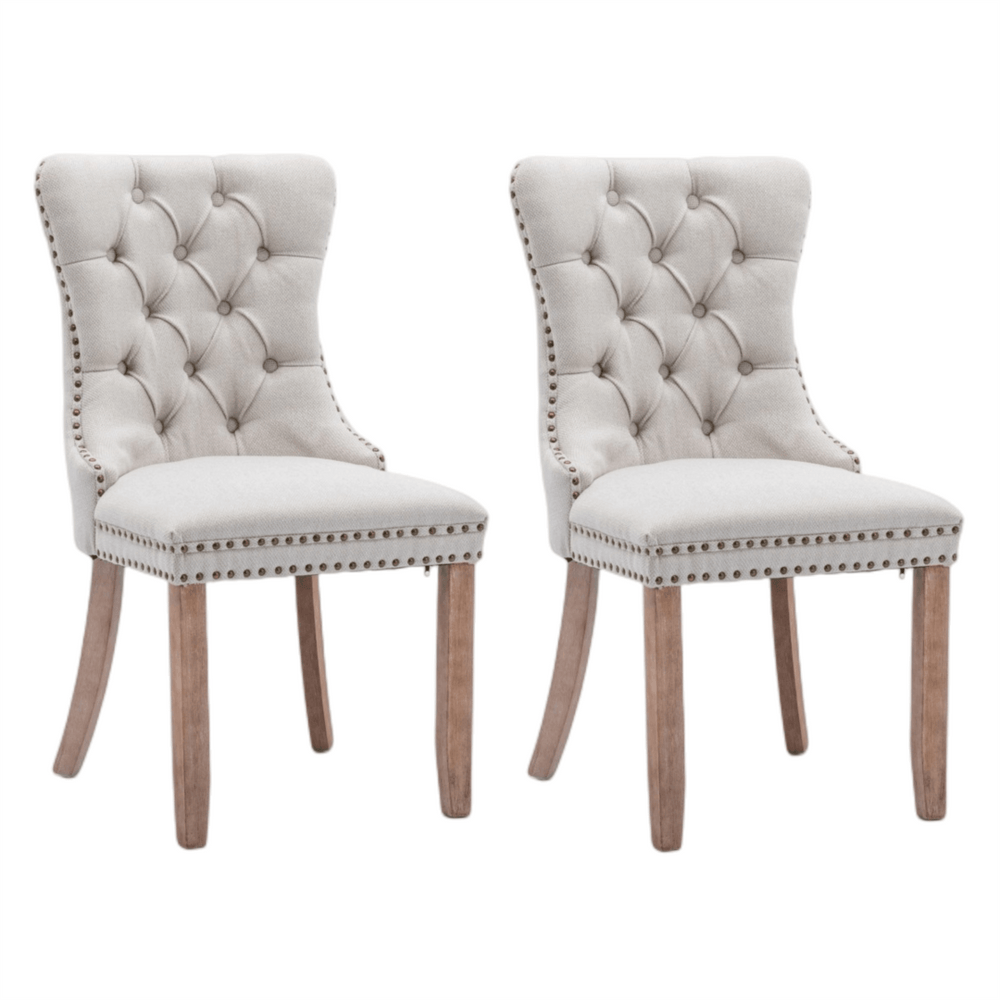 Pair of beige button-tufted dining side chairs with stud trim and wooden legs, perfect for affordable luxury decor.