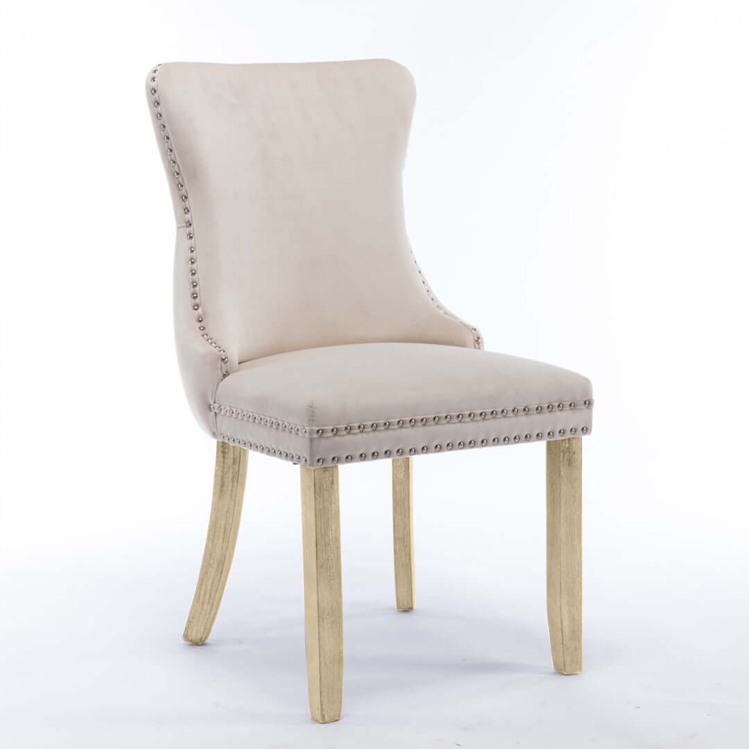 Velvet upholstered dining chair with tufted wingback design, studs trim, and solid wood legs for kitchen decor