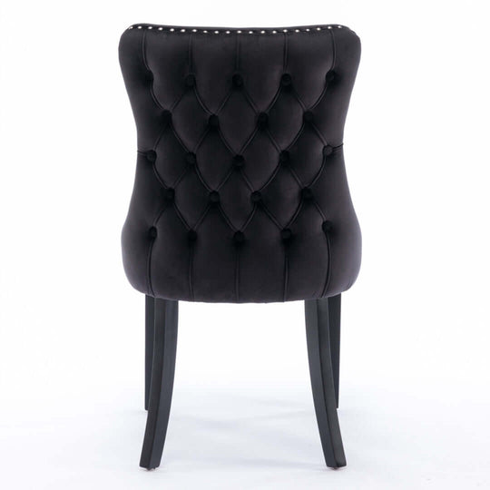 Black velvet tufted dining chair with studs trim and solid wood legs, rear view