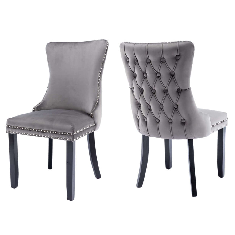 Velvet upholstered tufted wingback dining chairs with studs trim and solid wood legs in gray, front and back view.