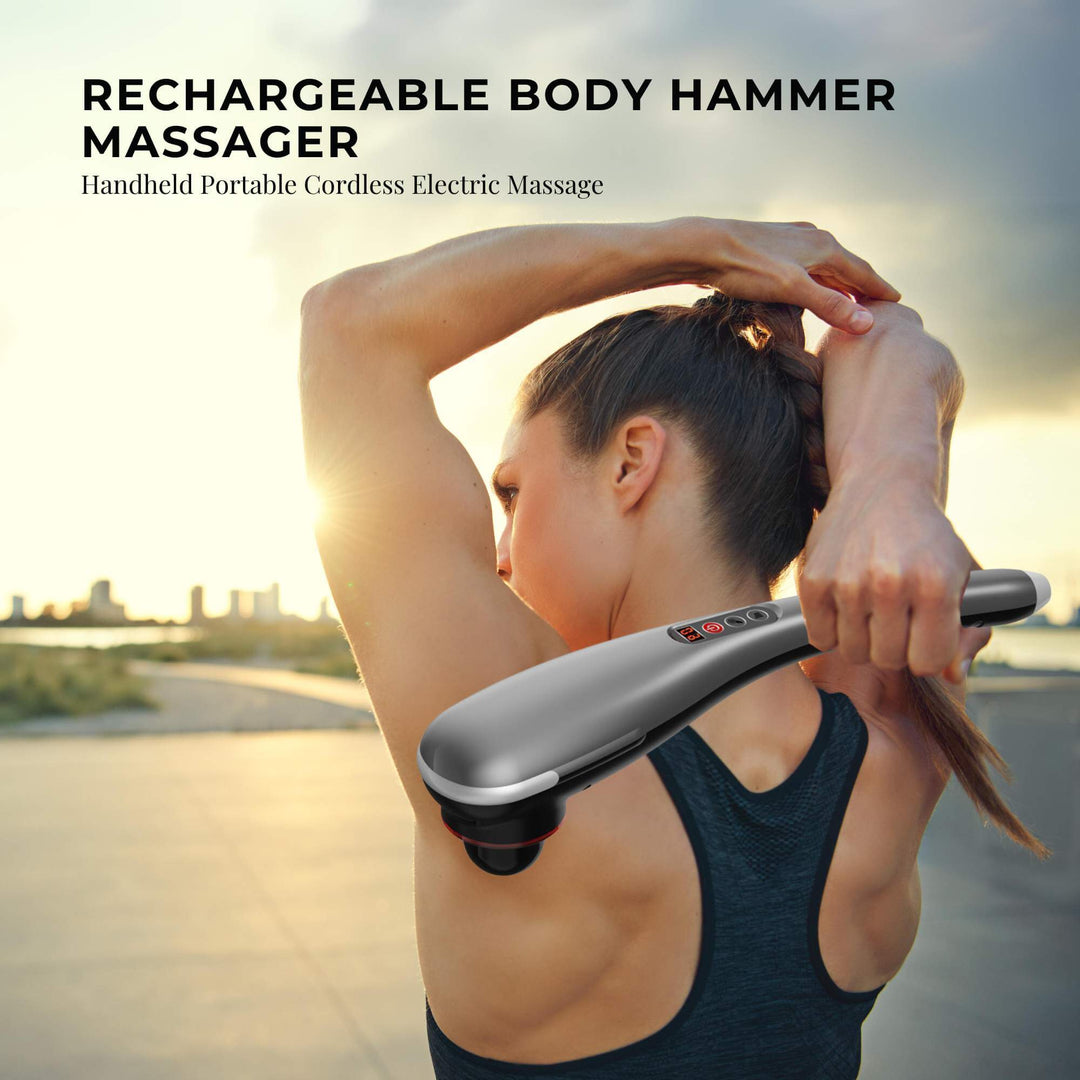 Woman using rechargeable body hammer massager for deep muscle relief in an outdoor setting.