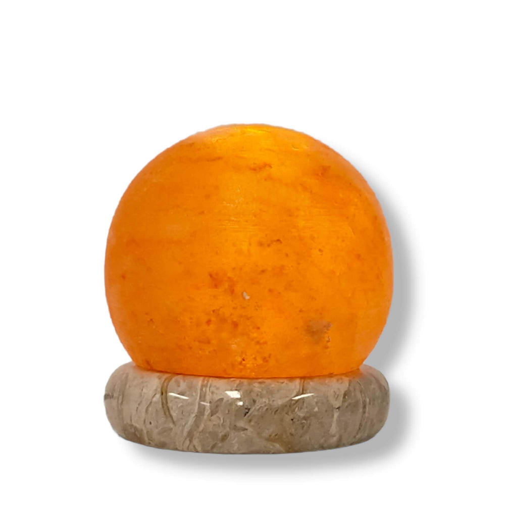 USB Himalayan salt lamp in ball shape with warm glow on a stone base, affordable quality home décor accent light.