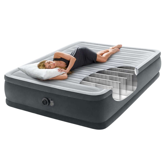 Woman peacefully sleeping on the Intex Dura-Beam Deluxe Queen air mattress, showcasing comfort and quality design.