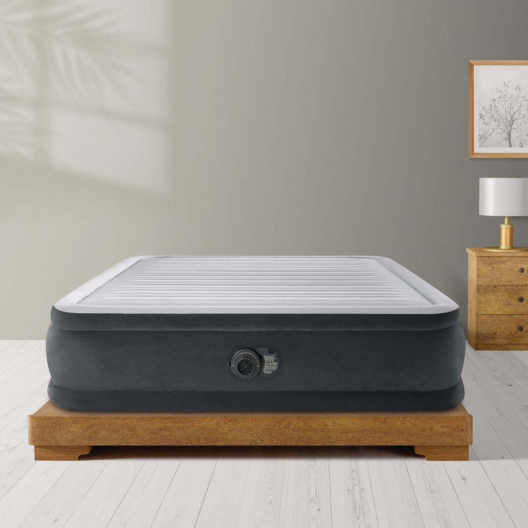 Intex Dura-Beam Deluxe Queen Comfort-Plush Elevated Air Mattress on wooden base in stylish bedroom setting.