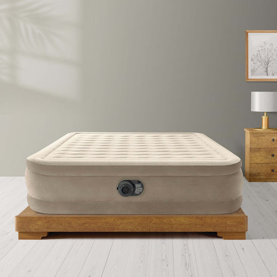 Intex Dura-Beam Deluxe Queen Ultra Plush Air Mattress on wooden platform, showcasing luxury and comfort for an affordable sleep solution.