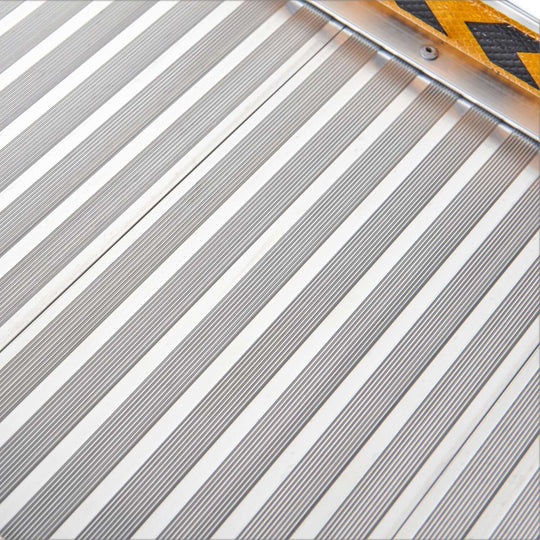 Close-up of the textured non-slip surface of a Rigg aluminium foldable wheelchair ramp.