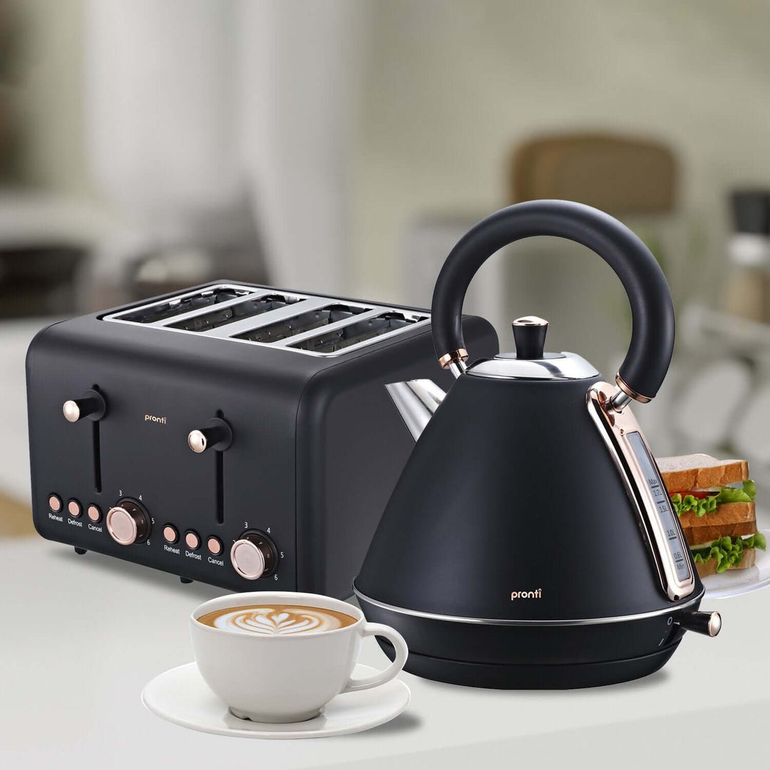 Pronti 4-Slice Toaster Rose Trim Collection in Black with matching kettle, cup of coffee, and sandwich on a modern kitchen counter.