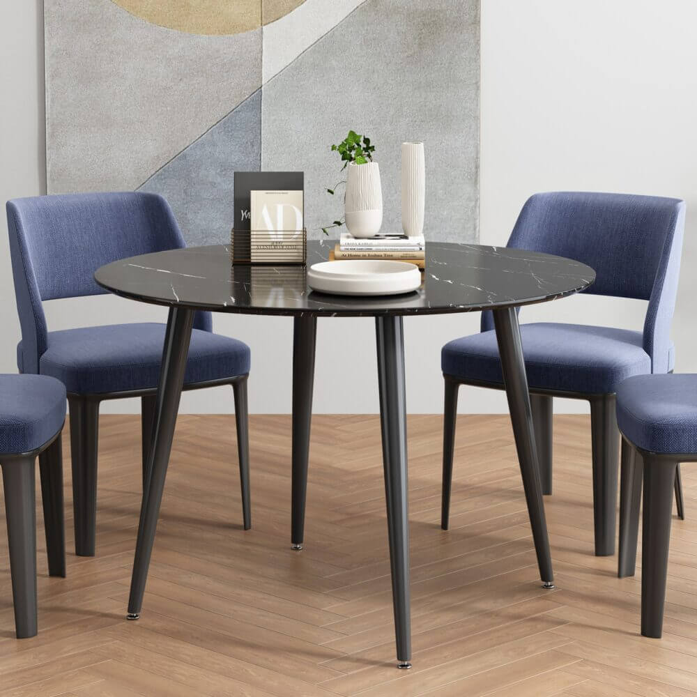 Round marble effect dining table with smooth edges, paired with blue chairs, creating a stylish medieval-inspired dining environment.