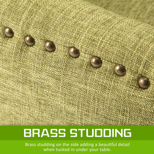 Close-up view of green fabric dining chair with brass studding detail for French Provincial style.