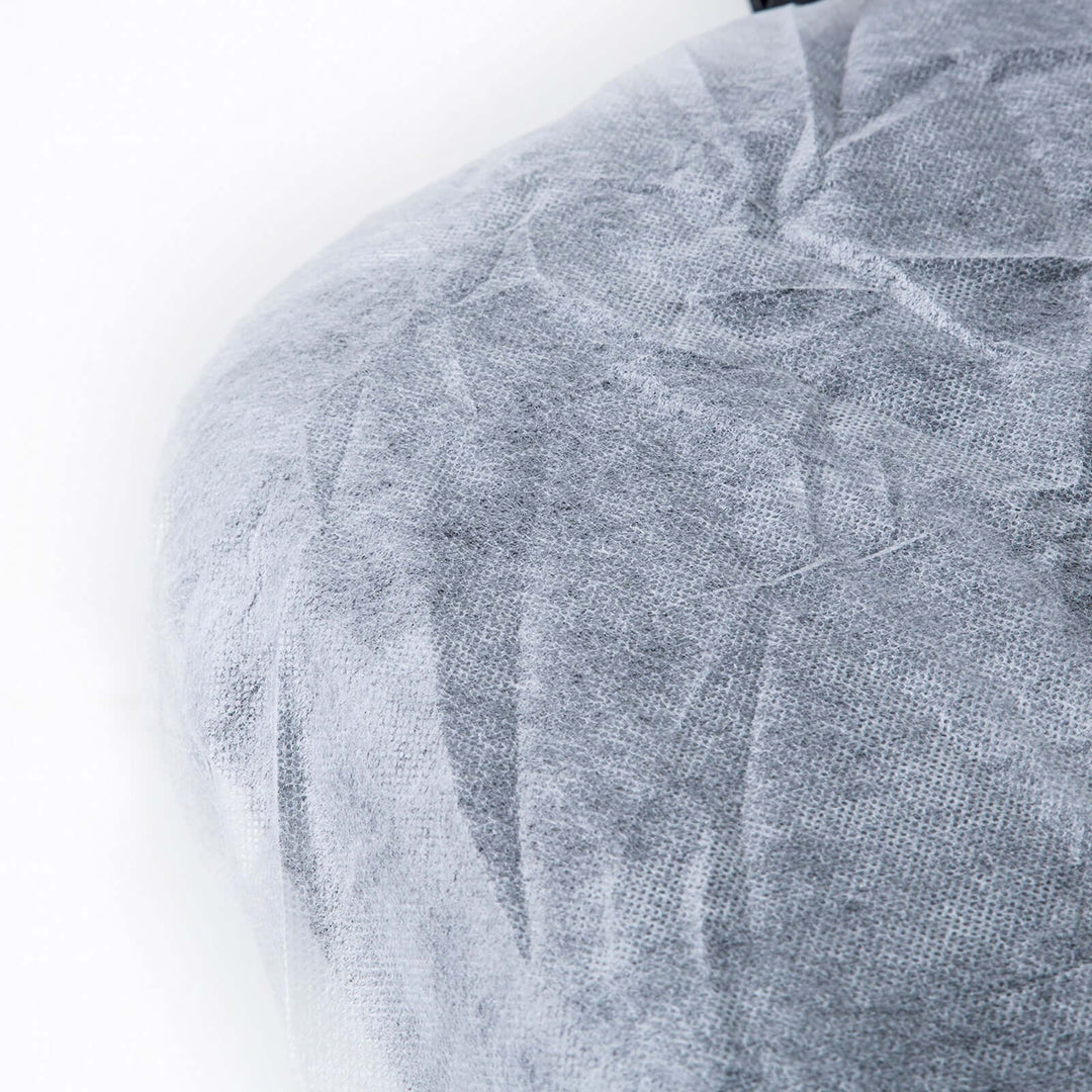 Close-up of a disposable massage table sheet cover in gray, highlighting its quality and affordable design for a luxury experience.